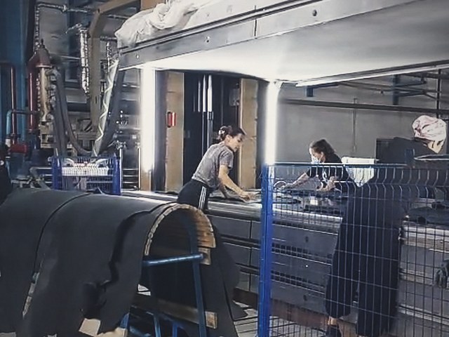 Operators loading hides at the vacuum drying line